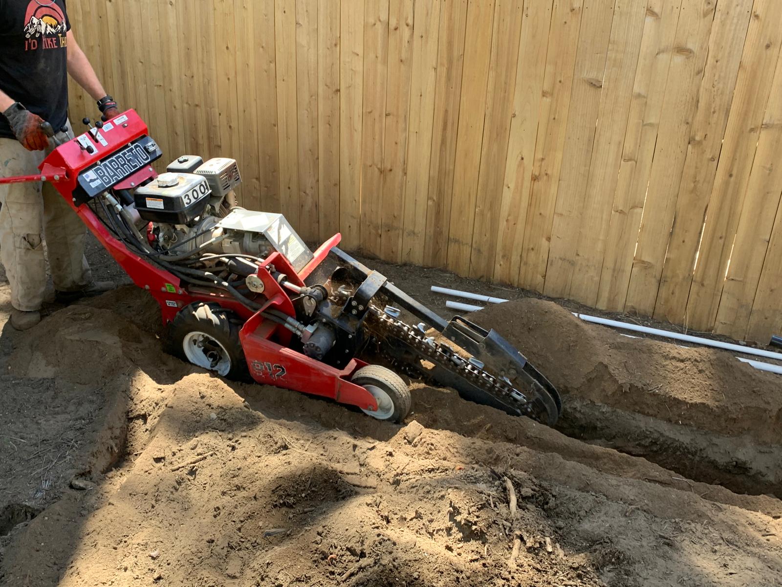 Stamparini Services crew running a walk-behind trencher for a utility line at a Tahoe property