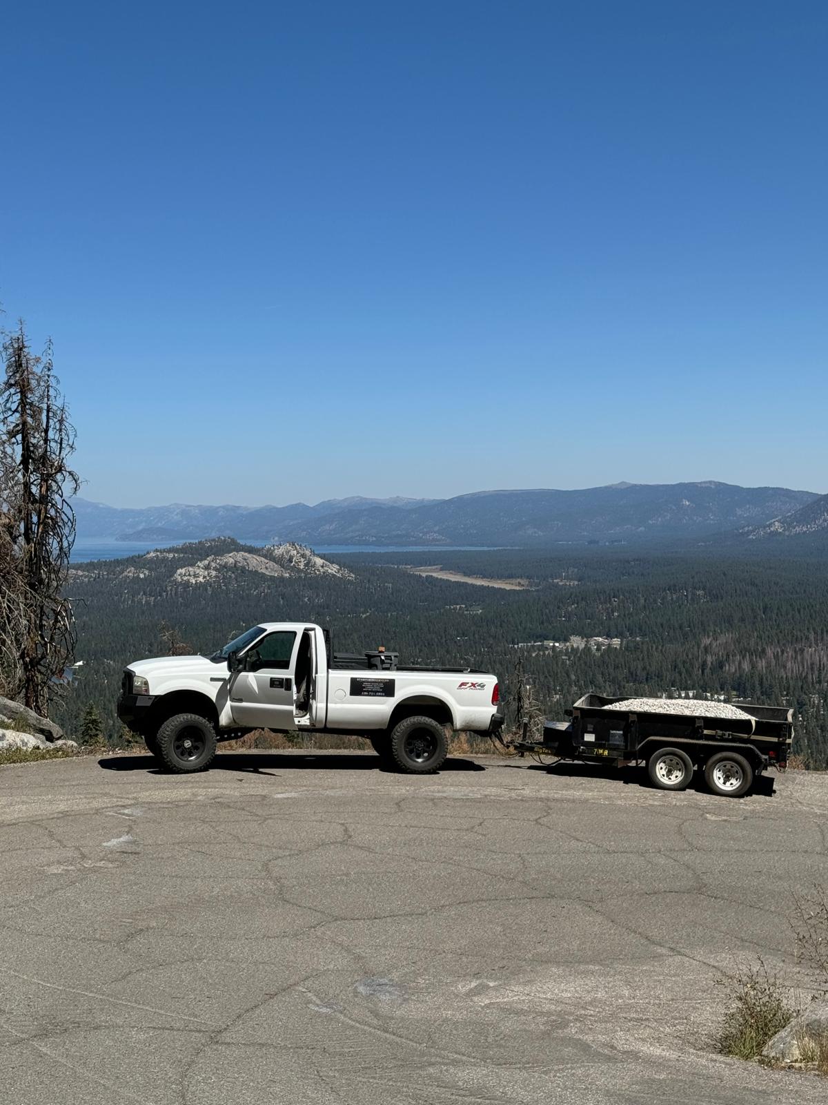Stamparini Services truck and dump trailer loaded with gravel above Lake Tahoe